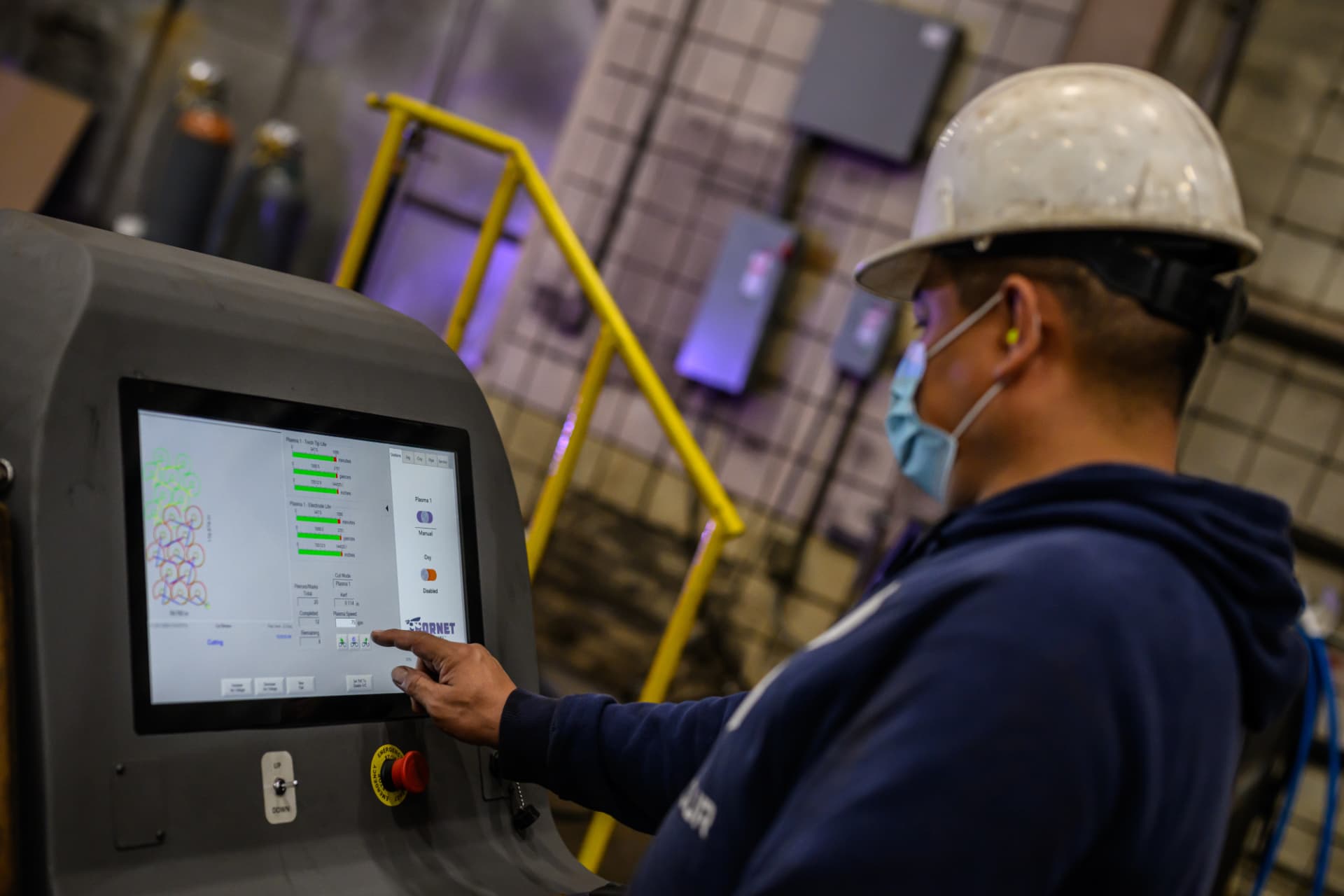 Manufacturing team member monitoring production controls