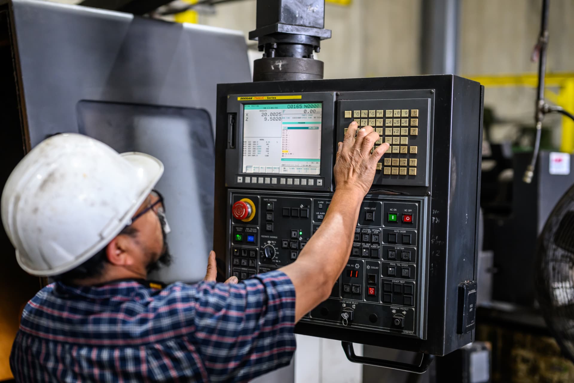 Operator setting the CNC machine controls